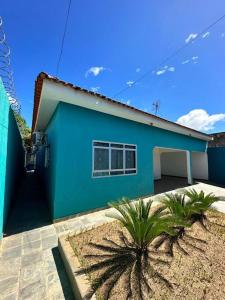 uma casa azul com uma palmeira em frente em Blue Home em Bodoquena