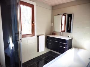 bagno bianco con lavandino e specchio di Chalet Mondego, paisible et tout confort a Gérardmer