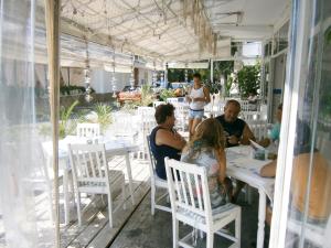 un grupo de personas sentadas en mesas en un restaurante en Family Hotel White House, en Pomorie