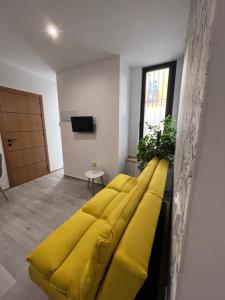 a yellow couch in a room with a tv at Apartamento Chic Centro in Dos Hermanas