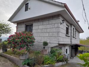 una casa con piante in vaso davanti di O Monteiriño a Arbo