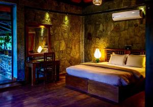 a bedroom with a bed with a stone wall at The Tea Cottage Resort & Spa in Nawalapitiya