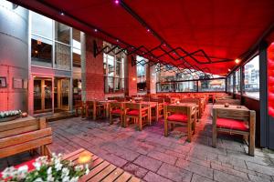 un restaurante con mesas de madera y sillas en un patio en Anno, en Almere