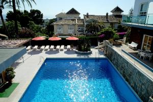 ein Pool vor einem Haus in der Unterkunft Hotel Complejo Los Rosales in Torremolinos