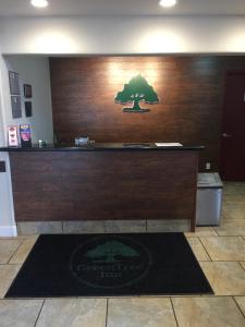 un mostrador de recepción con un árbol en la pared en GreenTree Inn Flagstaff en Flagstaff