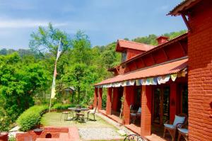 un edificio con un patio con mesa y sillas en Shivapuri Heights Cottage en Katmandú