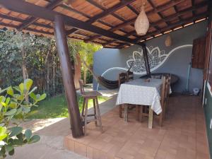 un patio con mesa y sillas bajo una pérgola en Little Kamala en Pipa