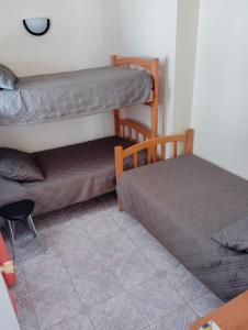 a bedroom with two bunk beds and a chair at APARTHOTEL Santa Maria in Punta de Choros