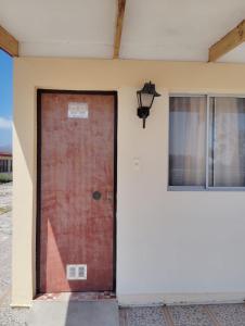 a red door on the side of a building at APARTHOTEL Santa Maria in Punta de Choros