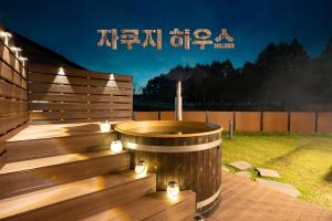 een hot tub op een terras met verlichting bij 르꼼떼블루 in Pyeongchang 