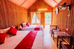 1 dormitorio con 2 camas, mesa y silla en Tam Coc Bungalow en Ninh Binh