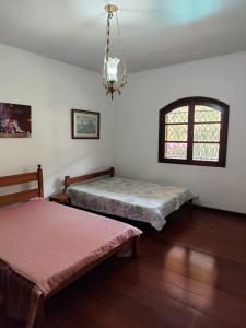 Habitación con 2 camas y ventana en Casa Aconchegante - Circuito Teresópolis Friburgo en Teresópolis