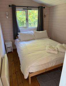 Cama grande en habitación con ventana en Cherry Tree Glamping en Stroud