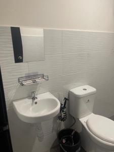 Baño blanco con aseo y lavamanos en Felina Homestay Condo Selayang Batu Caves MusIim OnIy, en Kuala Lumpur