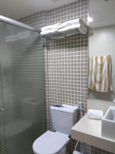 uma casa de banho com um chuveiro, um WC e um lavatório. em Suites Beach Park Resort - Pé na areia- Ao lado do Parque Aquático adm Por Anfitrião em Aquiraz