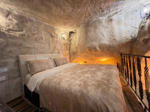 1 dormitorio con 1 cama en una habitación de piedra en Atilla's Cave Hotel en Nevşehir