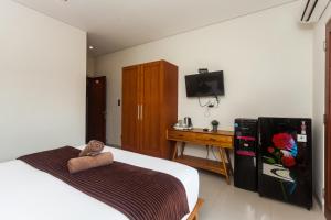 Kleines Zimmer mit einem Bett und einem Kühlschrank. in der Unterkunft Naksa Homestay Sanur in Sanur