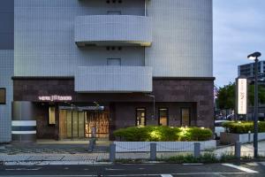 un edificio con un cartel en el costado en Hotel JIN Morioka Ekimae en Morioka