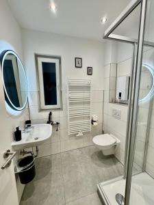 uma casa de banho branca com um lavatório e um WC em MEINpartments - Modern Business Apartment em Wolfsburg