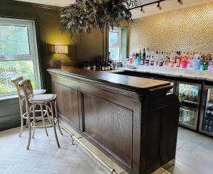 un bar con barra de madera y sillas en una habitación en Tŷ Afon - River House en Beddgelert