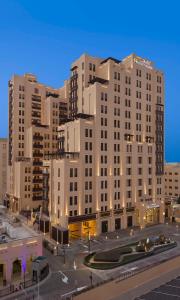 een groot wit gebouw in een stad 's nachts bij Hyatt Place Dubai Wasl District in Dubai