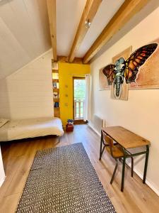 Zimmer mit einem Bett und einem Tisch sowie einem Schmetterling an der Wand in der Unterkunft Maisonnette au cœur du village in Châteauvieux