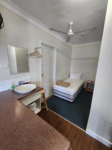 un bagno con lavandino e un letto in una camera di T's Resort & Motel a Port Macquarie