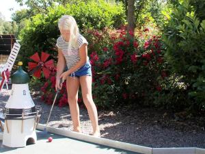 Une fille jouant avec un ballon de golf dans une cour dans l'établissement 6 person holiday home in Hasle, à Hasle