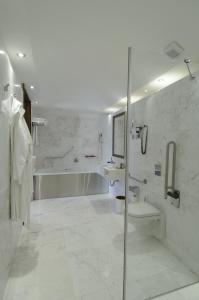 La salle de bains blanche est pourvue d'une douche et d'un lavabo. dans l'établissement The Library Hotel Wellness Retreat, à Kalavasos