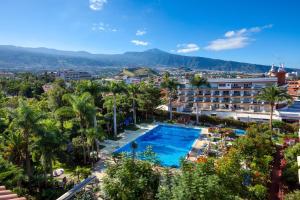 - une vue sur un complexe avec une piscine et des palmiers dans l'établissement Apartamentos Masaru, à Puerto de la Cruz