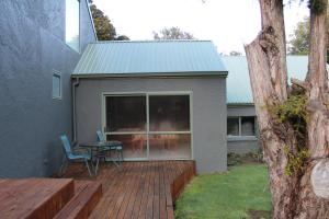 d'une terrasse avec une table et des chaises. dans l'établissement Tui Hideaway, à Invercargill