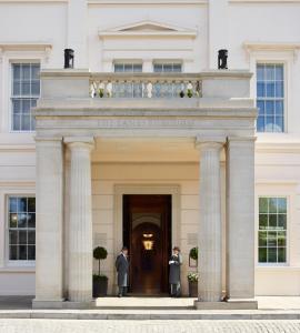 ロンドンにあるThe Lanesborough, Oetker Collectionの白い建物の入口に立つ二人