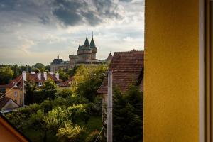 widok na zamek z miasta z dachami w obiekcie Apartmany Hujer w mieście Bojnice