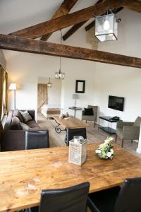 uma sala de estar com uma mesa de madeira e um sofá em Appartementen Leonardus em Valkenburg