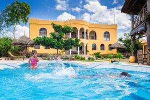 una niñita jugando en el agua en una piscina en Zan View Hotel, en Kiwengwa