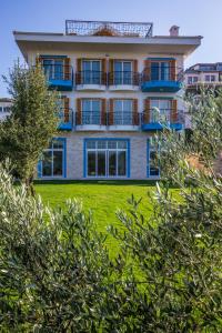 ein Apartmenthaus mit Balkon auf einer Wiese in der Unterkunft Clementin Suits Sigacık in Siğacık