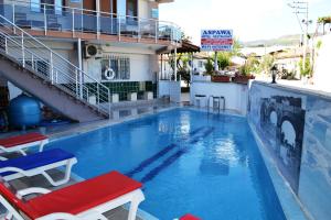 una grande piscina con due sedie rosse e blu di Aspawa Hotel a Pamukkale