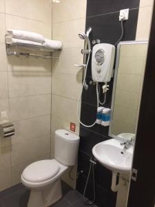 Baño pequeño con aseo y lavamanos en Hi Star Hotel en Sitiawan