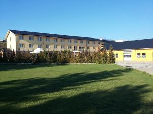 un grande edificio con un grande prato di fronte di Hotel Auto Jas a Nitra