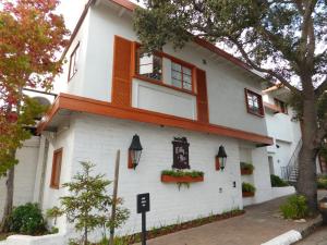 un edificio blanco con ventanas y flores. en Tally Ho Inn en Carmel