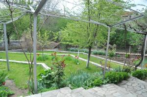 un jardín con flores y pérgola en Holiday Home Vilata en Kŭrdzhali