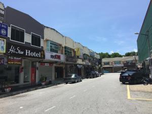 una calle de ciudad vacía con coches aparcados en la calle en Hi Star Hotel en Sitiawan