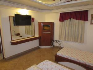 a room with a mirror and a tv on the wall at Pleasant Place Hotel in Sao Paulo