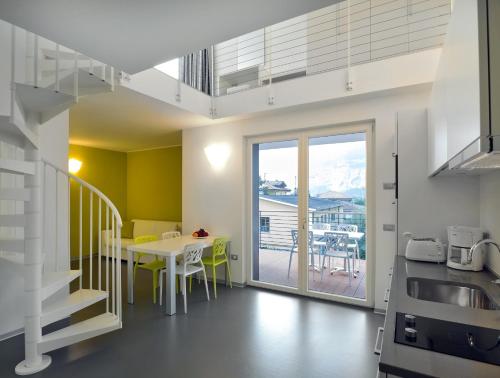 une cuisine et une salle à manger avec une table et un balcon dans l'établissement Gardabike Residence, à Nago-Torbole