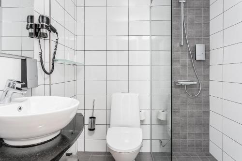 La salle de bains est pourvue d'un lavabo, de toilettes et d'une douche. dans l'établissement Hotell Nova, à Karlstad