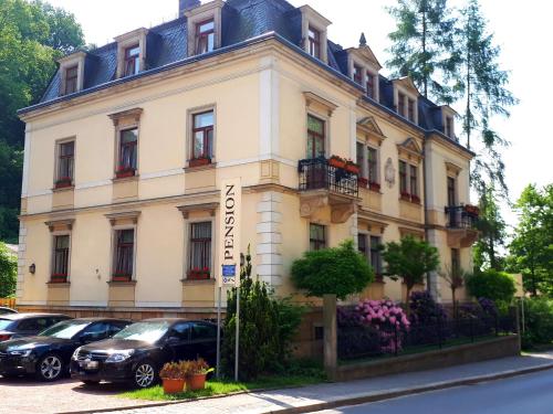 un edificio con coches estacionados frente a él en Gästehaus Loschwitz en Dresden