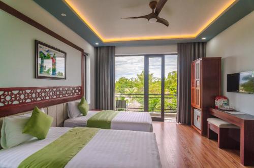 um quarto de hotel com duas camas e uma varanda em Tue Tam Garden Villa em Hoi An