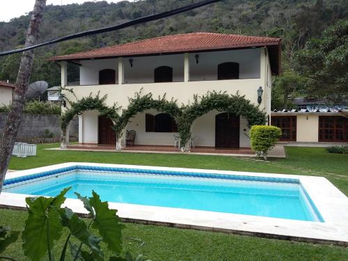 Villa con piscina frente a una casa en Casa Aconchegante - Circuito Teresópolis Friburgo en Teresópolis