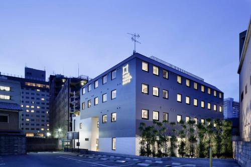 un bâtiment dans une ville avec des bâtiments dans l'établissement Piece Hostel Kyoto, à Kyoto