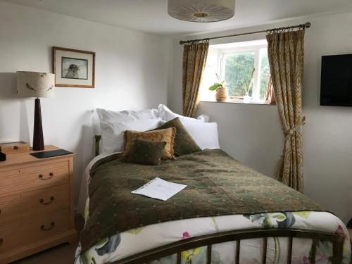 A bed or beds in a room at Coombe Lodge Farm House